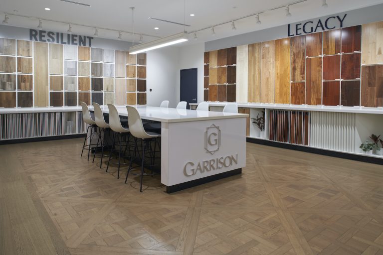 The Garrison Van Nuys showroom with flooring samples on the walls and a beautiful custom wooden floor